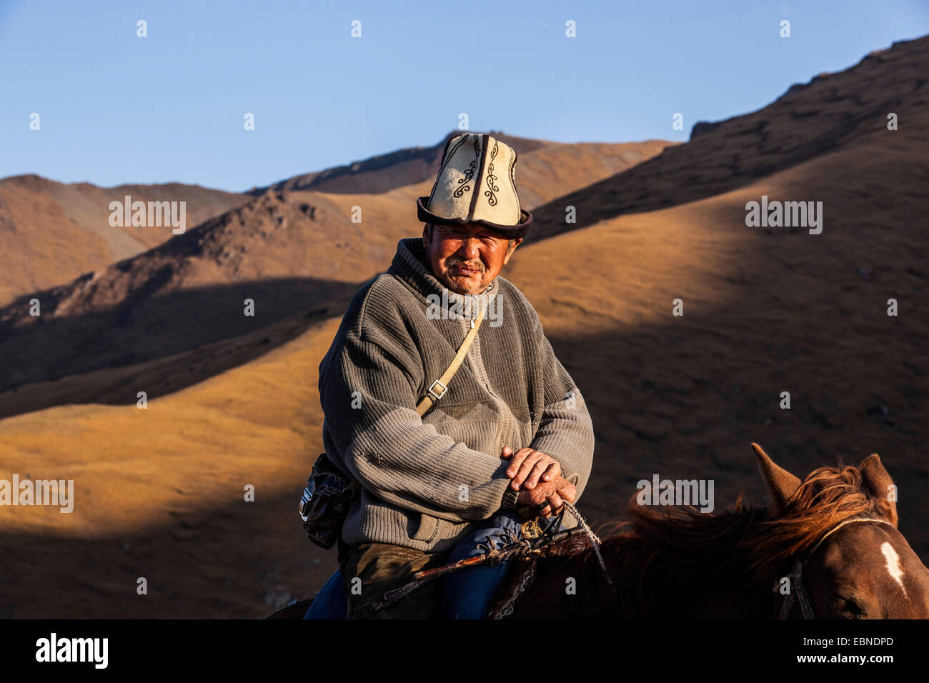 Kirghizian gardian sur son cheval près du lac Song Kol, Kirghizistan, Naryn Banque D'Images Kirghizian gardian sur son cheval près du lac Song Kol, Kirghizistan, Naryn Banque D'Images