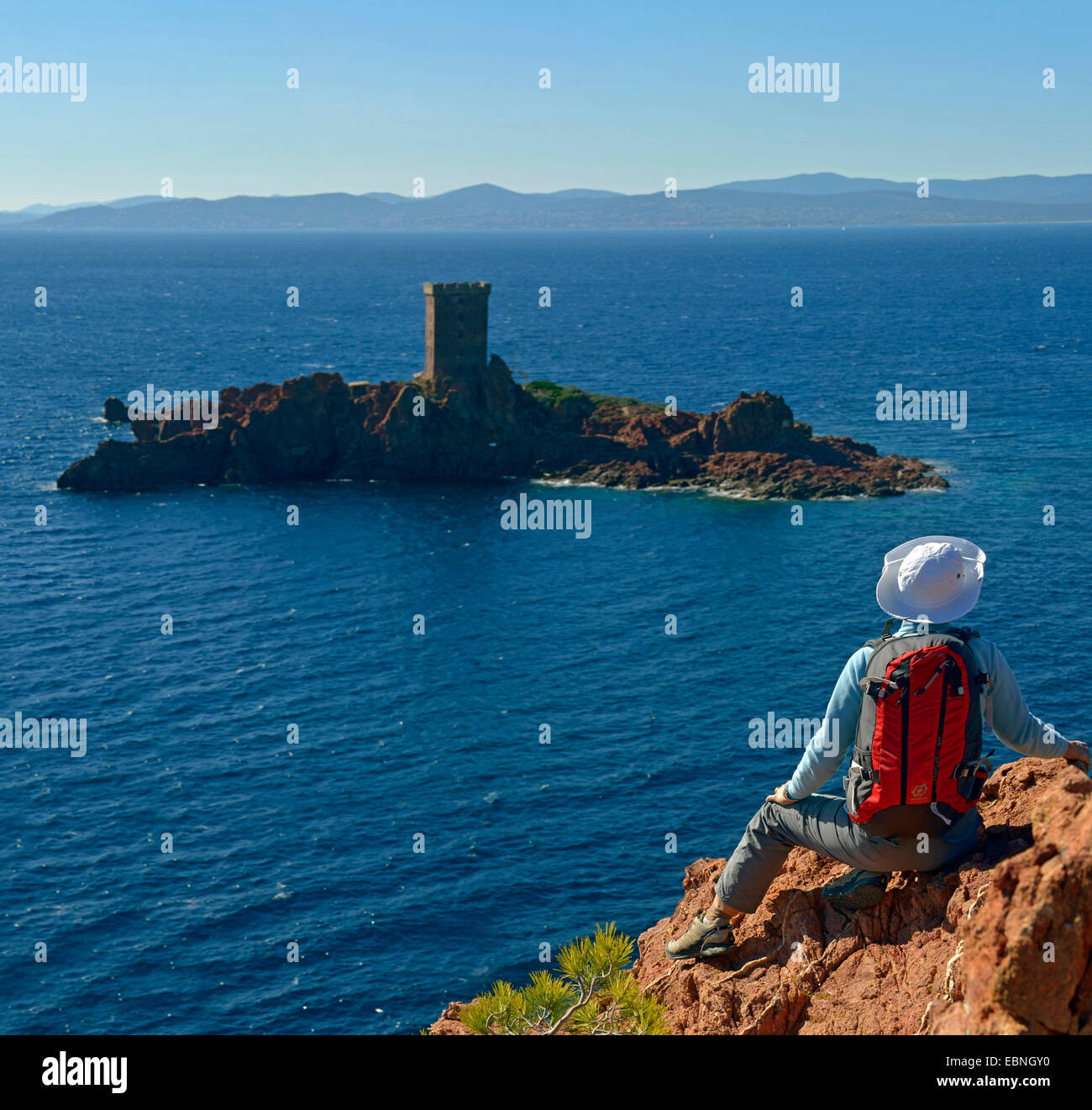 Femme assise sur côte rocheuse de Le Dramont et profiter de la vue de l'Ile, dAEOr France, Esterel , Saint Raphael Banque D'Images