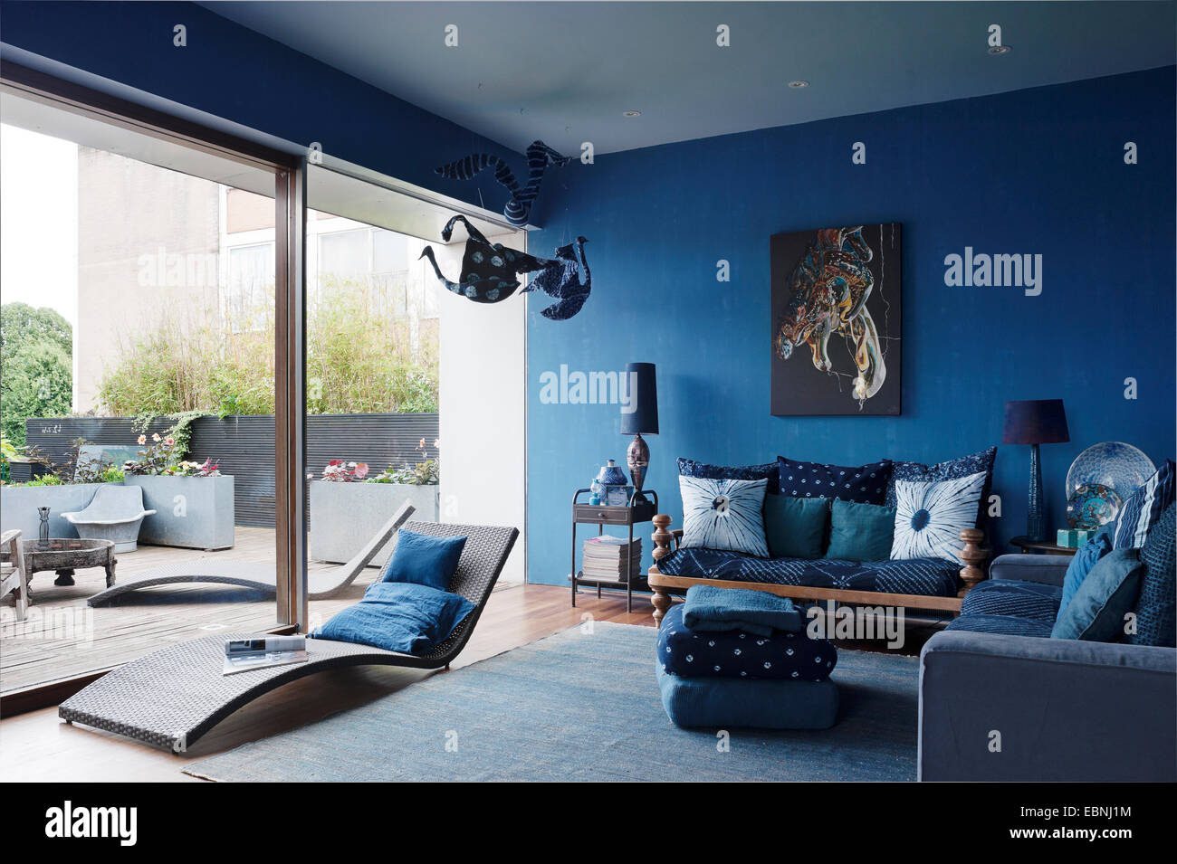 Blue salon avec fenêtres à la française. Le canapé à droite est d'Ikea, chaise longue de la piscine de voler en France et à l'oeuvre de Banque D'Images