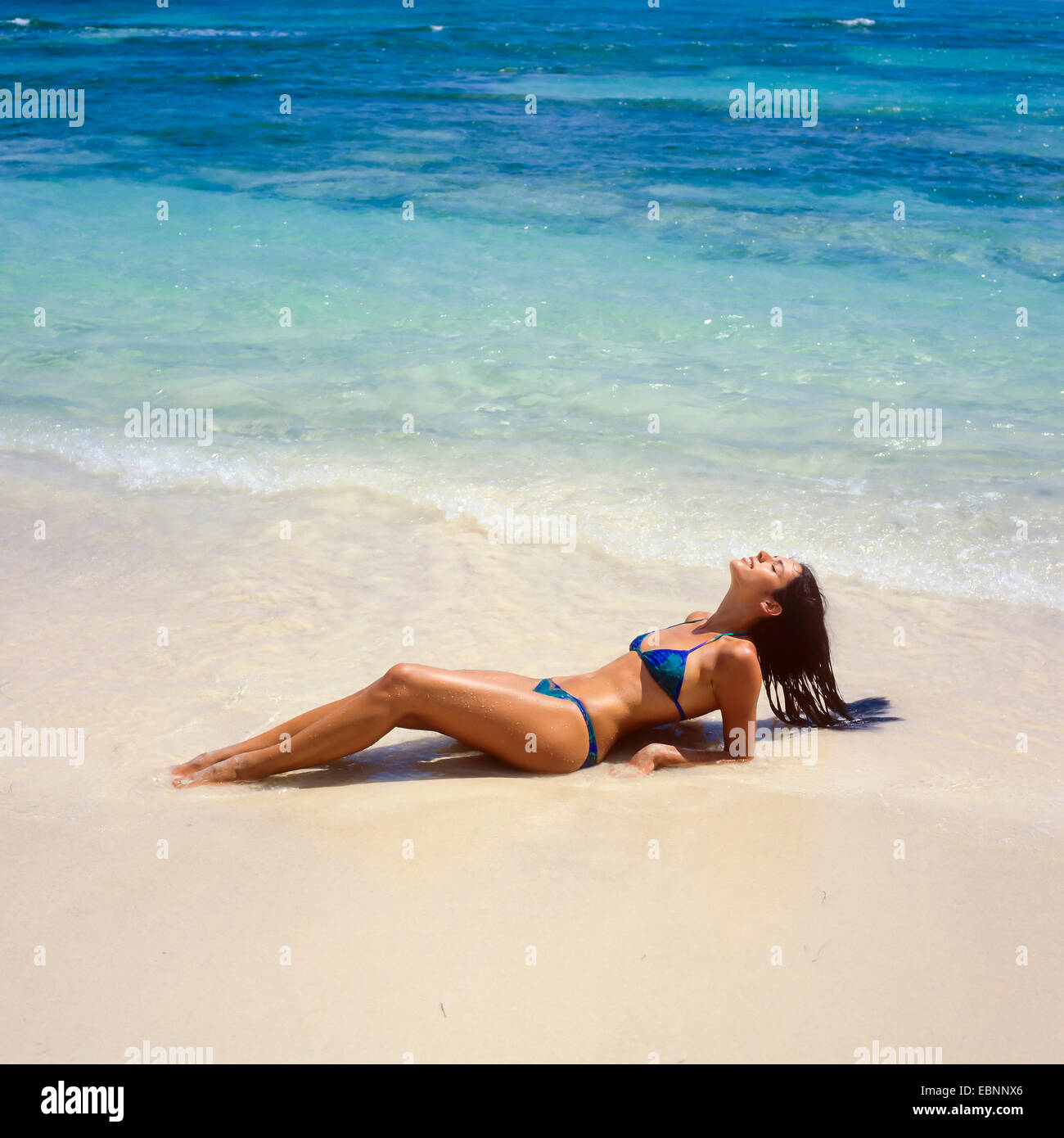 Jeune femme couchée et à bronzer sur la plage des Caraïbes, Guadeloupe, French West Indies, Petites Antilles Banque D'Images