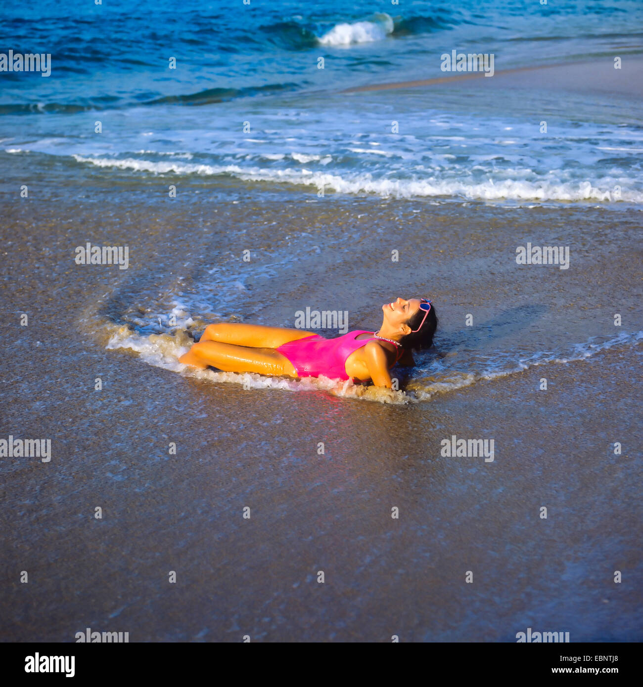 Jeune femme au soleil dans l'eau peu profonde sur une plage des Caraïbes, Guadeloupe, French West Indies Banque D'Images