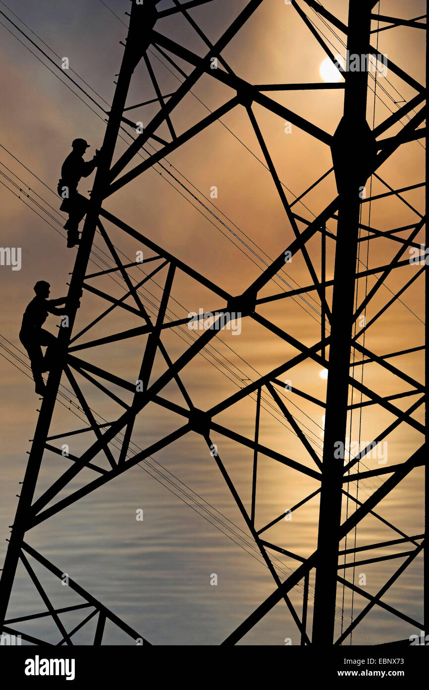 Electriciens de grimper sur le poteau électrique, Allemagne Banque D'Images