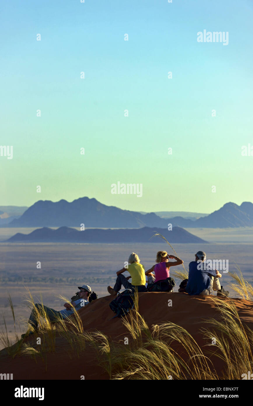 Séance de groupe sur une dune dans le désert et profiter de la vue, la Namibie, le Parc National Namib Naukluft Sesriem Camp, Banque D'Images