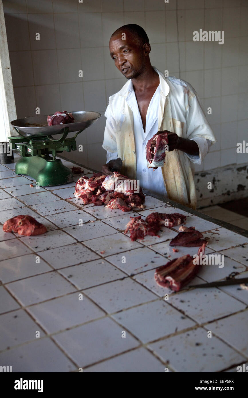 Boucher sur le marché public offrant de la viande de chèvre frais aux clients dans de mauvaises conditions d'hiegene, Rwanda, Kigali, Nyamirambo Banque D'Images