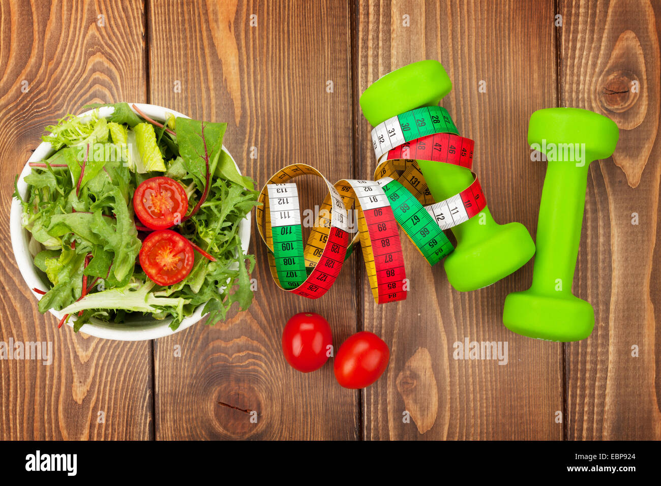 Dumbells, ruban de mesure et d'aliments sains sur table en bois. Santé et Fitness Banque D'Images