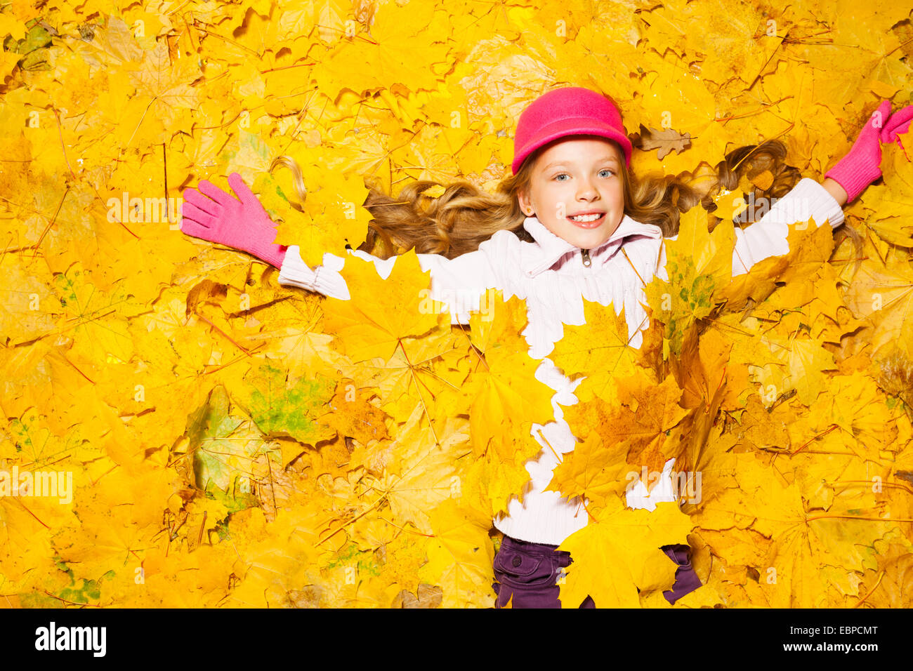 Happy smiling girl recouverte de feuilles d'automne Banque D'Images
