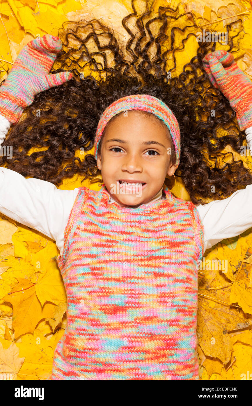 Happy African girl en feuilles d'automne jaune d'érable Banque D'Images