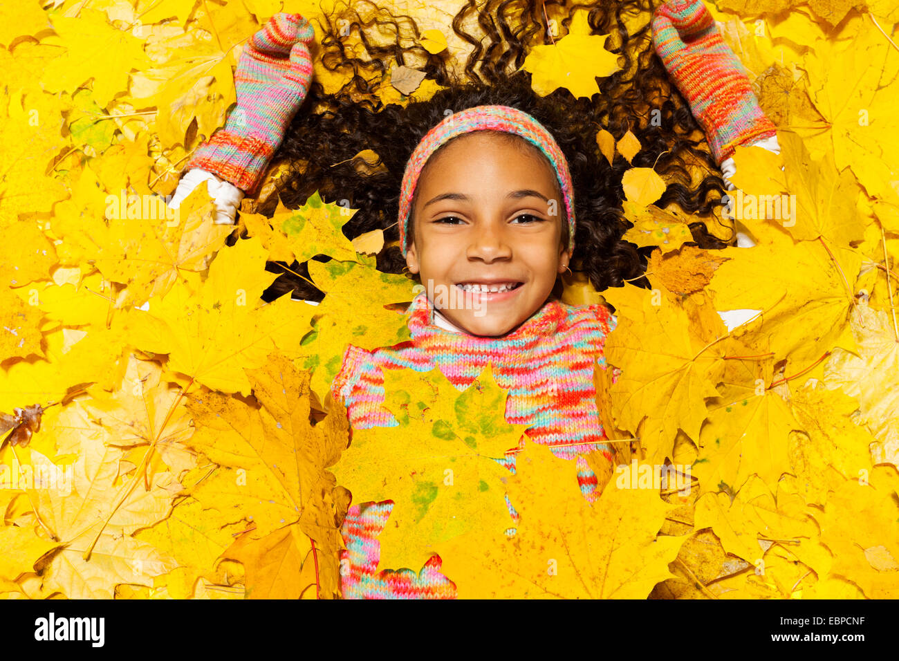 Petite fille africaine recouverte de feuilles d'érable Banque D'Images