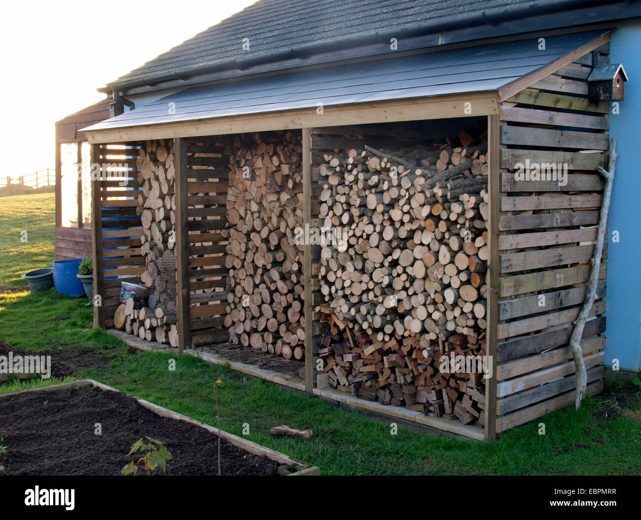 Magasin de bois rond sur le côté de la maison, Widemouth Bay, Bude, Cornwall, UK Banque D'Images