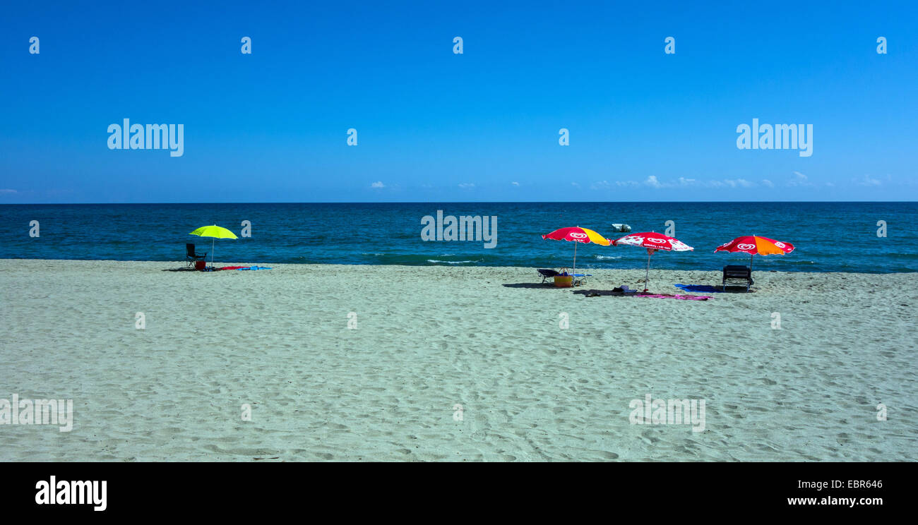 Quatre parasols de plage, avec une plage de sable et mer bleu Banque D'Images