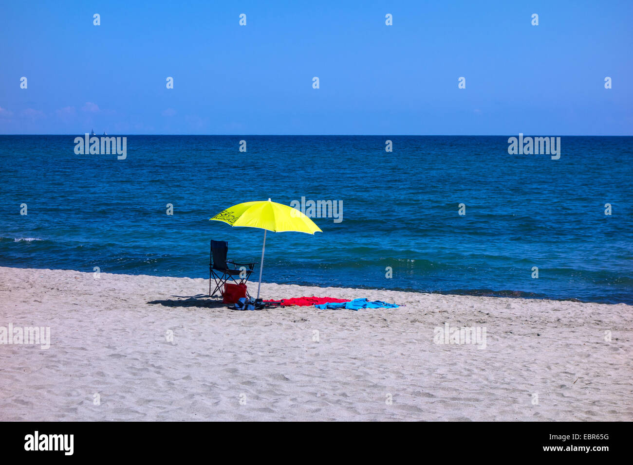 Parasol jaune avec chaise et serviette, avec plage de sable fin et la mer bleue, Solenzara Banque D'Images