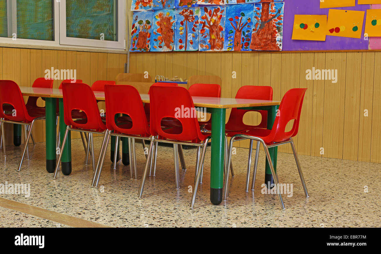 Des chaises rouges et des bancs d'une école maternelle pour les jeunes enfants Banque D'Images