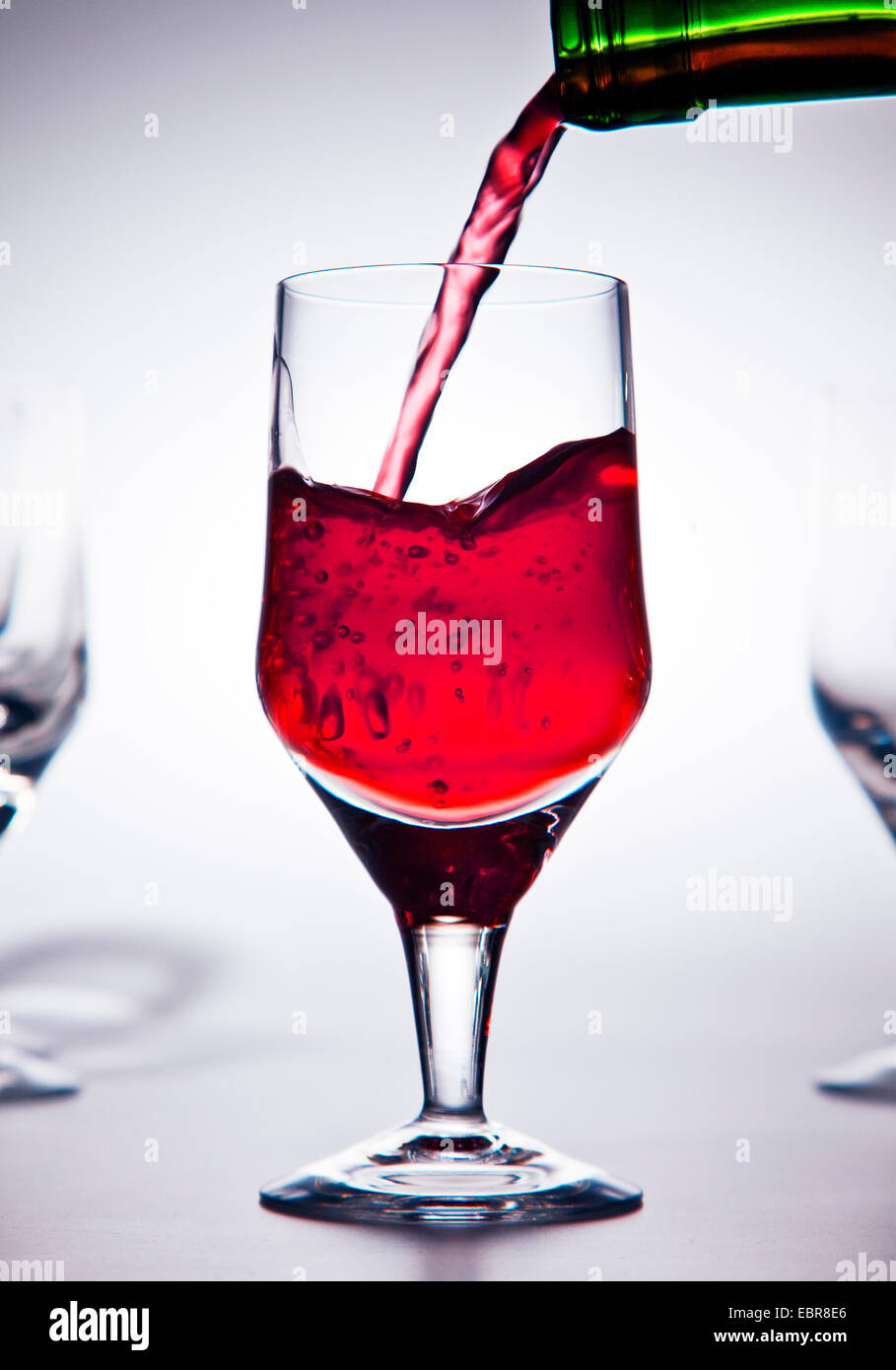 Le vin rouge est versé dans un verre à vin Banque D'Images