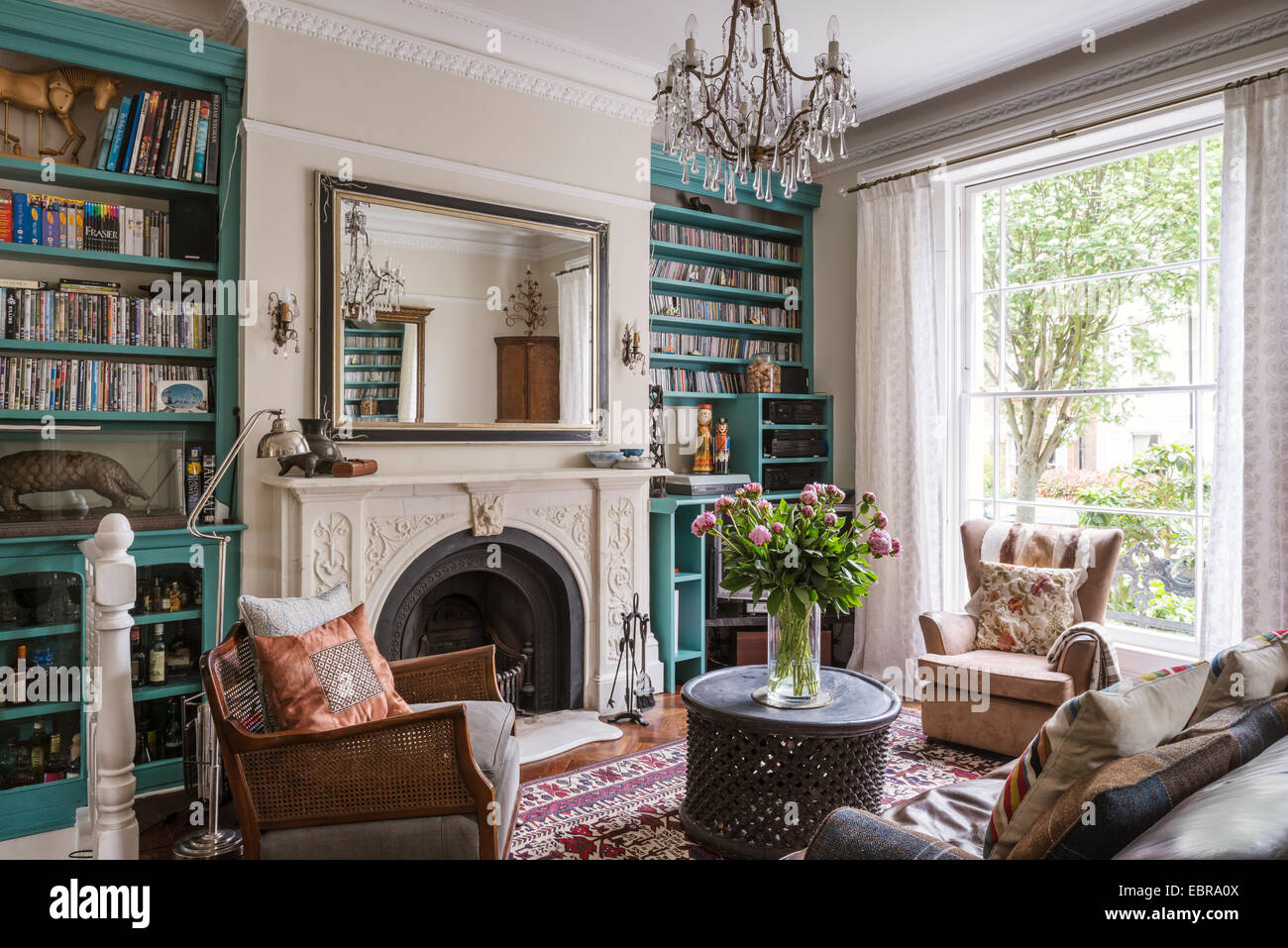 Rayonnage Turquoise dans l'élégant salon avec cheminée en marbre et un lustre en cristal Banque D'Images
