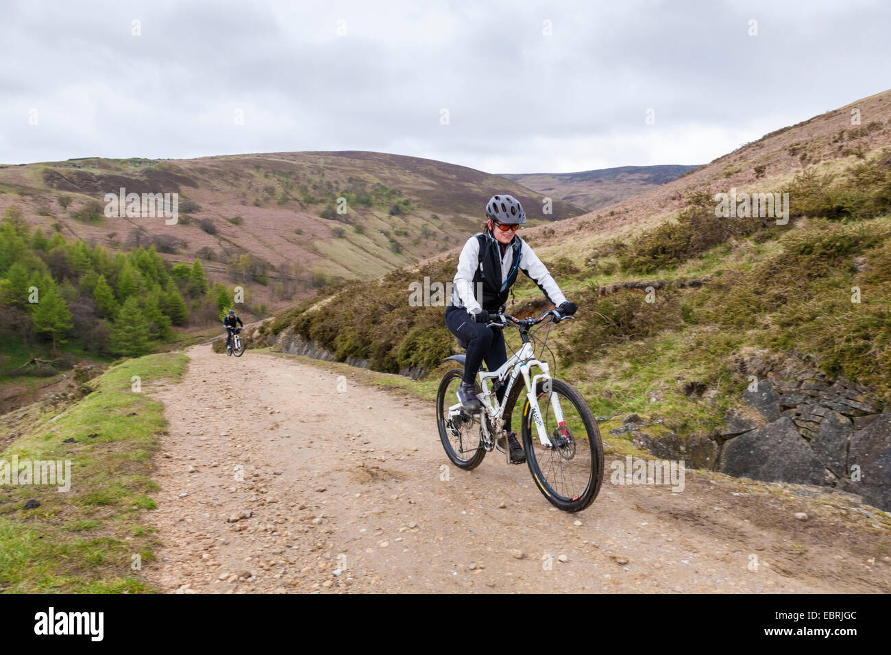 Vélo femme jusqu'à une colline sur une piste pierreuse. Jaggers Clough, Peak District, Derbyshire, Angleterre, RU Banque D'Images