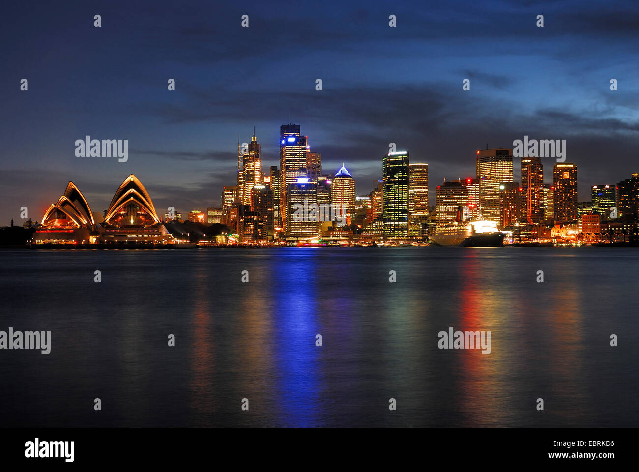 L'Opéra de Sydney et le Queen Elizabeth 2 revêtement d'océan en face de la skyline de Sydney en lumière du soir, Circular Quay, Sydney Cove, Australie, New South Wales, Sydney Banque D'Images