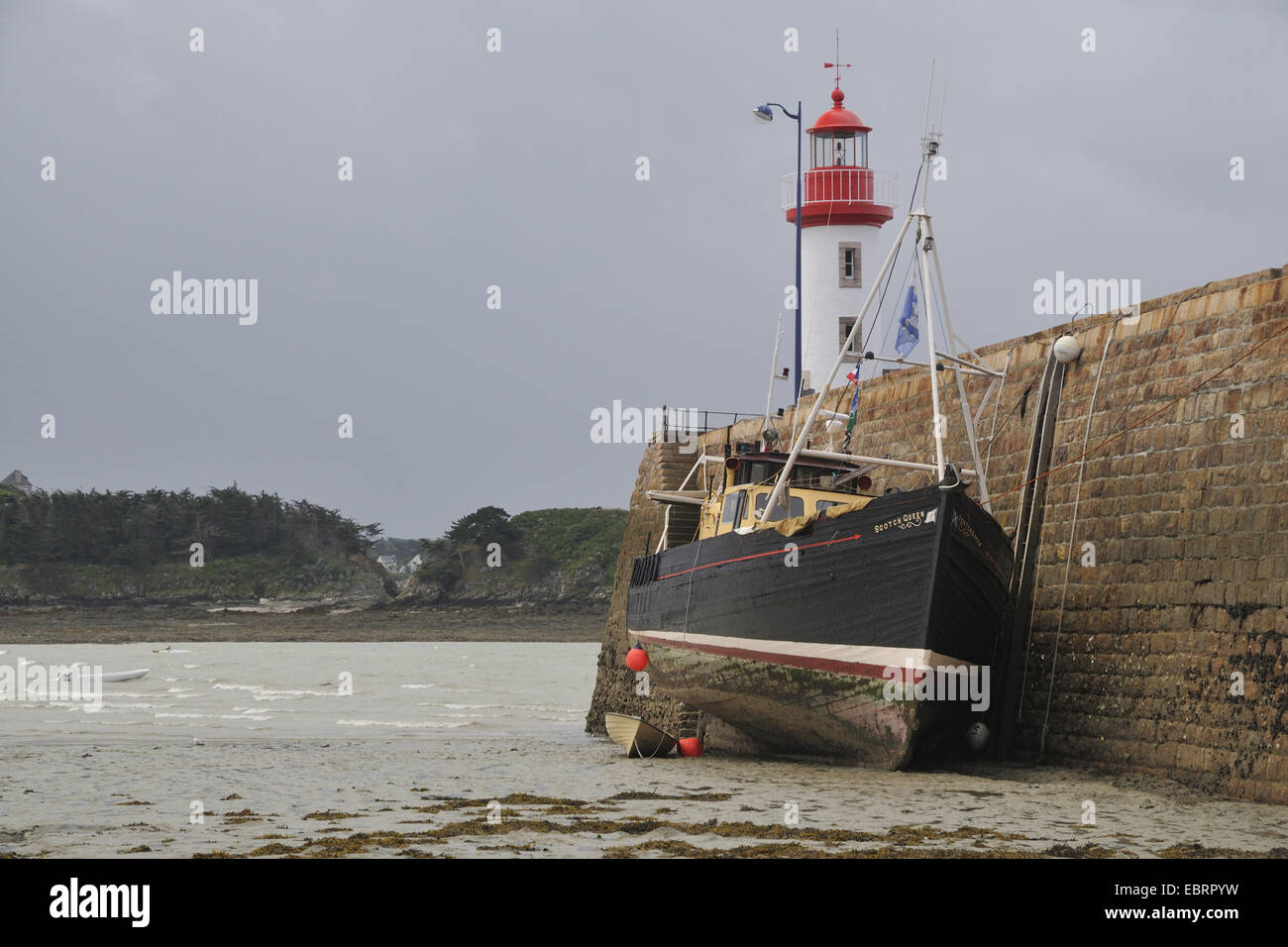 Vieux bateau au phare d'Erquy à marée descendante, France, Bretagne, Erquy Banque D'Images