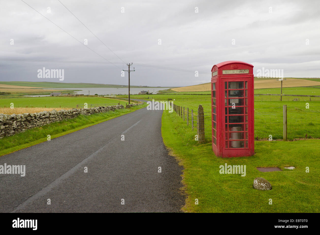 Téléphone fort à côté d'un solitaire country road, Royaume-Uni, Ecosse, Orcades, Orkney Mainland Banque D'Images