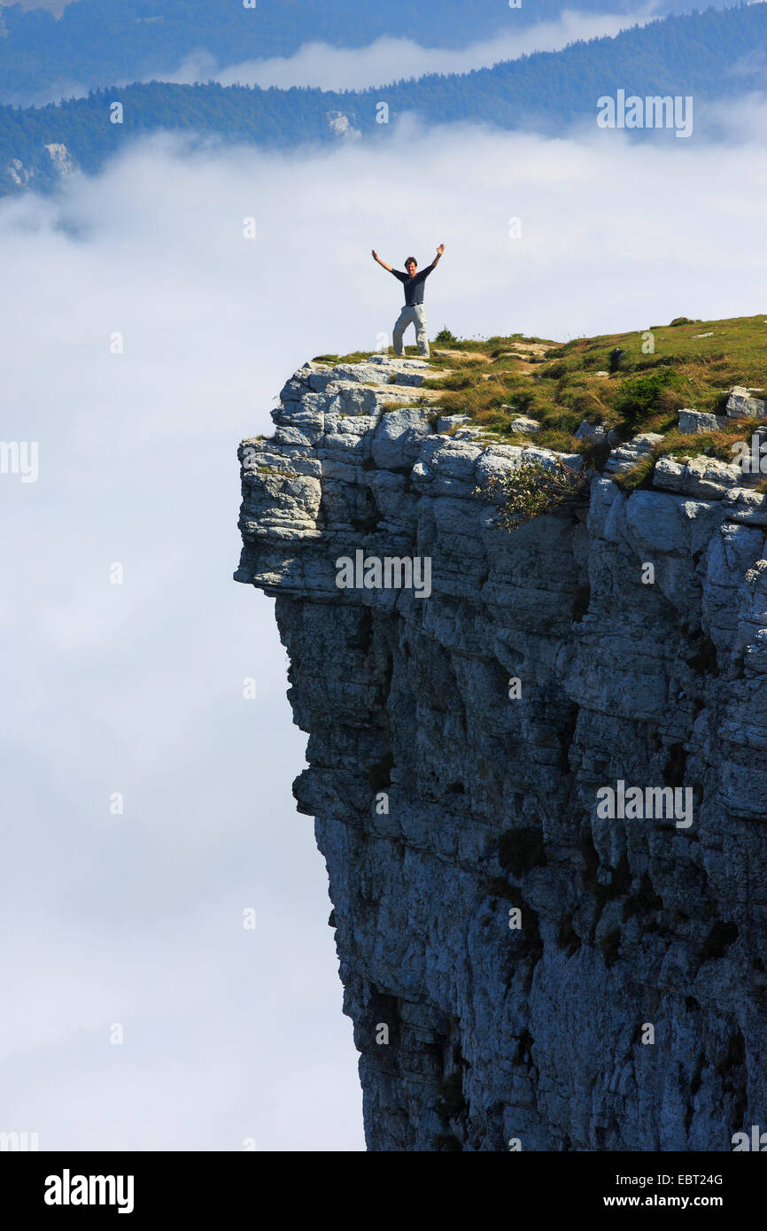 Homme debout au bord d'une face raide du cirque rocheux naturel Creux du Van, Suisse, Neuchâtel Banque D'Images