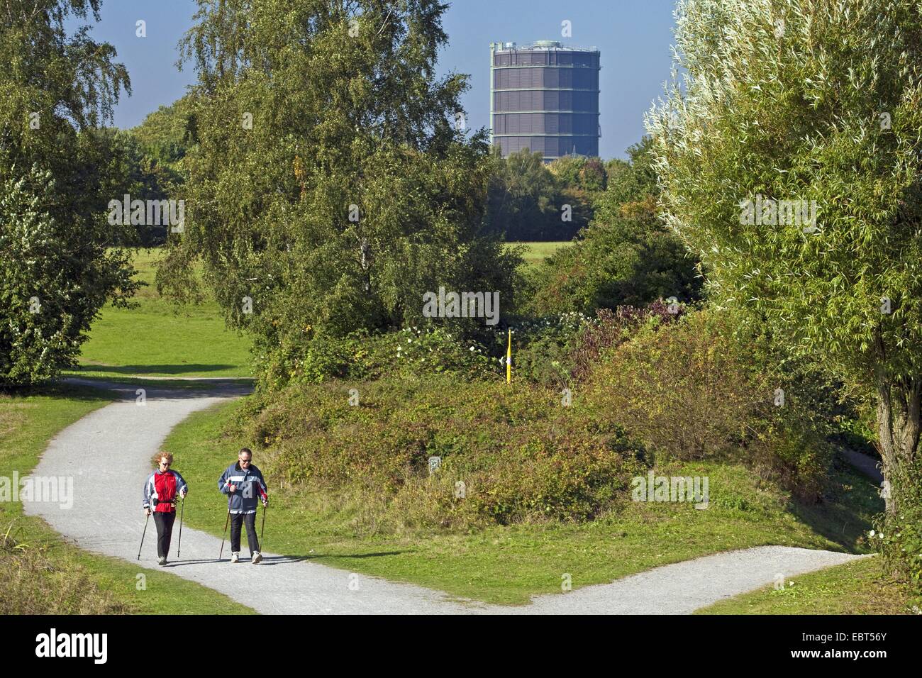 Deux Nordic Walker dans le jardin d'arbres et d'arbustes, Ripshorst Gazomètre Oberhausen en arrière-plan, l'Allemagne, en Rhénanie du Nord-Westphalie, Ruhr, Oberhausen Banque D'Images