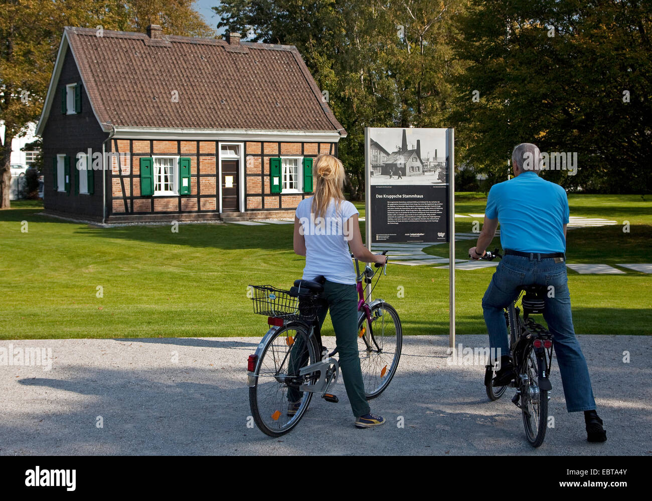 Deux personnes avec des vélos debout au panneau d'information à l'entreprise originale construction de Krupp, l'Allemagne, en Rhénanie du Nord-Westphalie, région de la Ruhr, à Essen Banque D'Images
