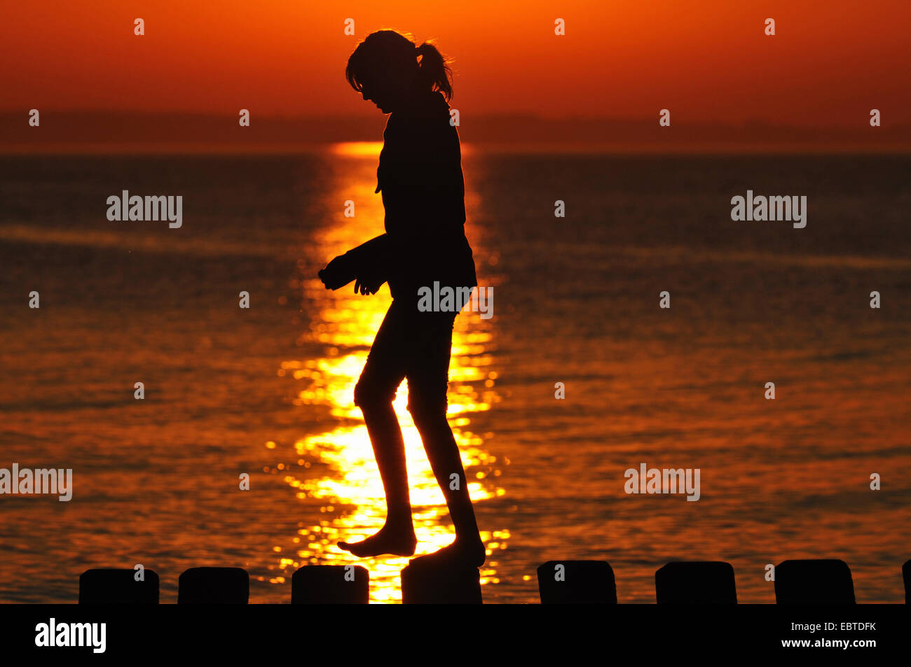 Femme marche sur épi au coucher du soleil, de l'Allemagne, Mecklembourg-Poméranie-Occidentale Banque D'Images