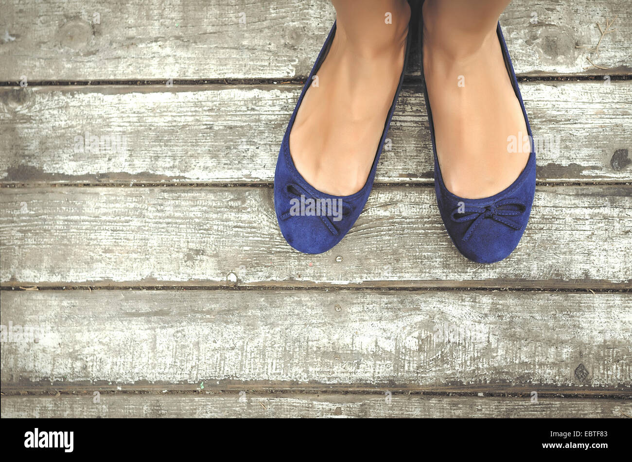 Les filles belles chaussures bleu sur terrasse en bois Banque D'Images