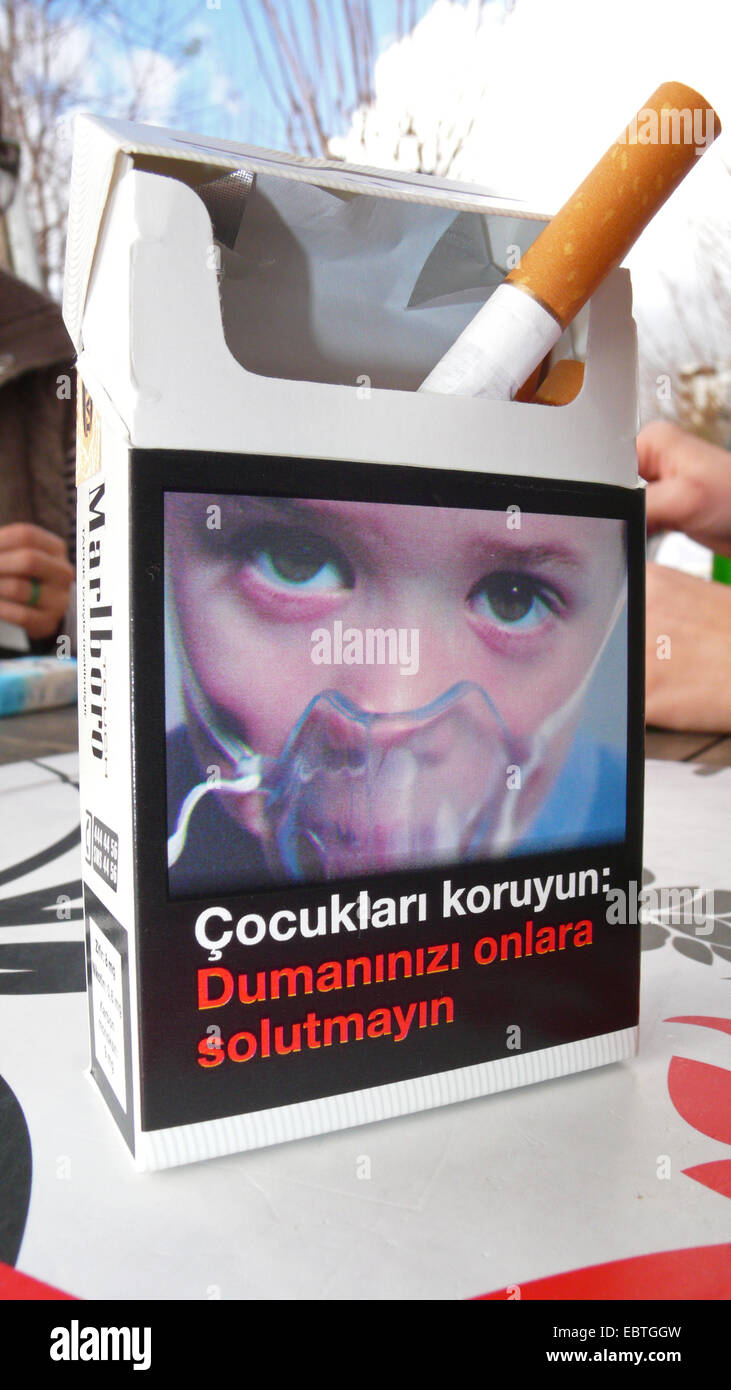 Paquet de cigarettes avec la photo d'un enfant portant un masque respiratoire debout sur la table d'un café de la rue, Turquie Banque D'Images