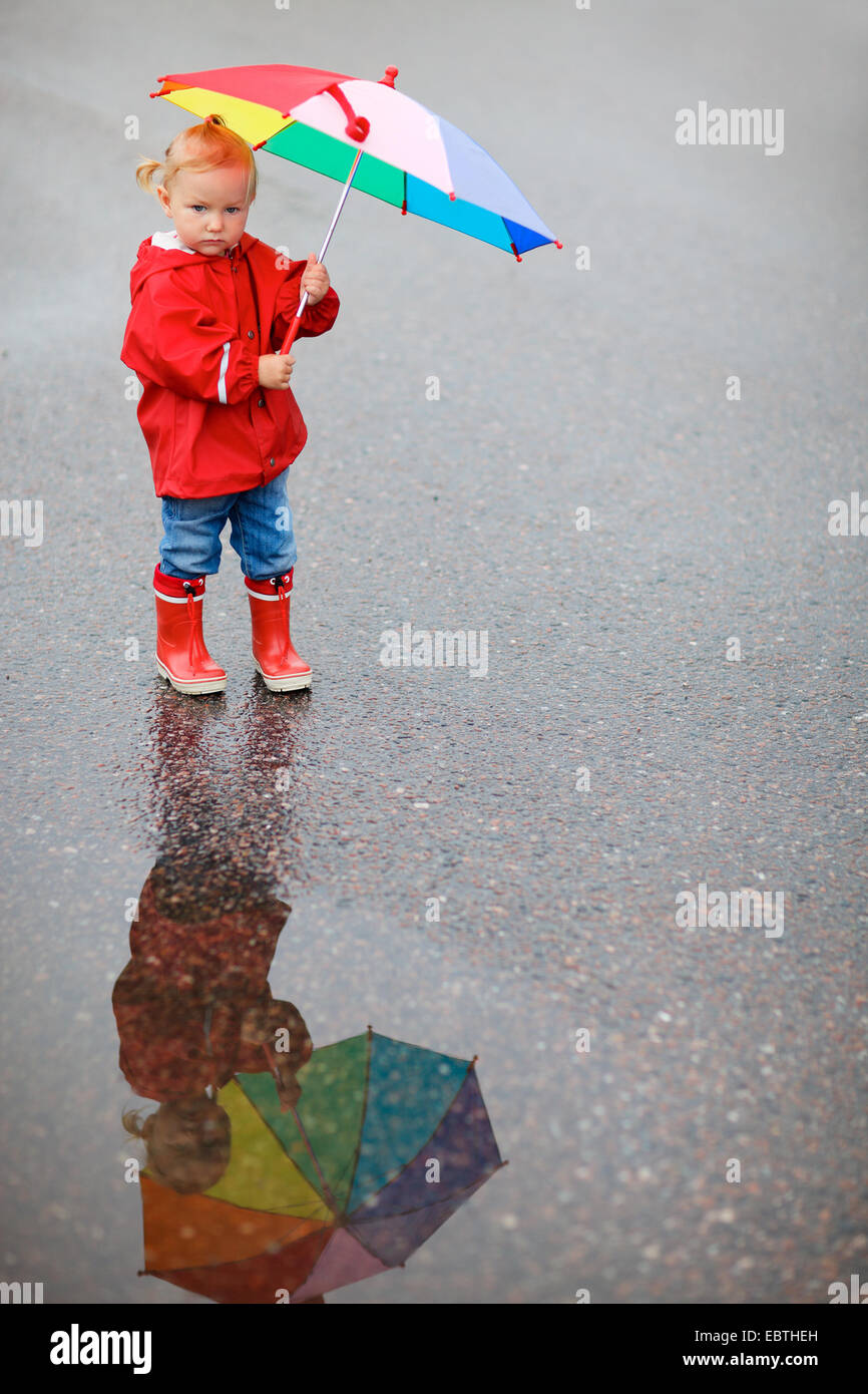 Petite fille en vêtements de pluie avec parapluie ouvert Photo Stock - Alamy