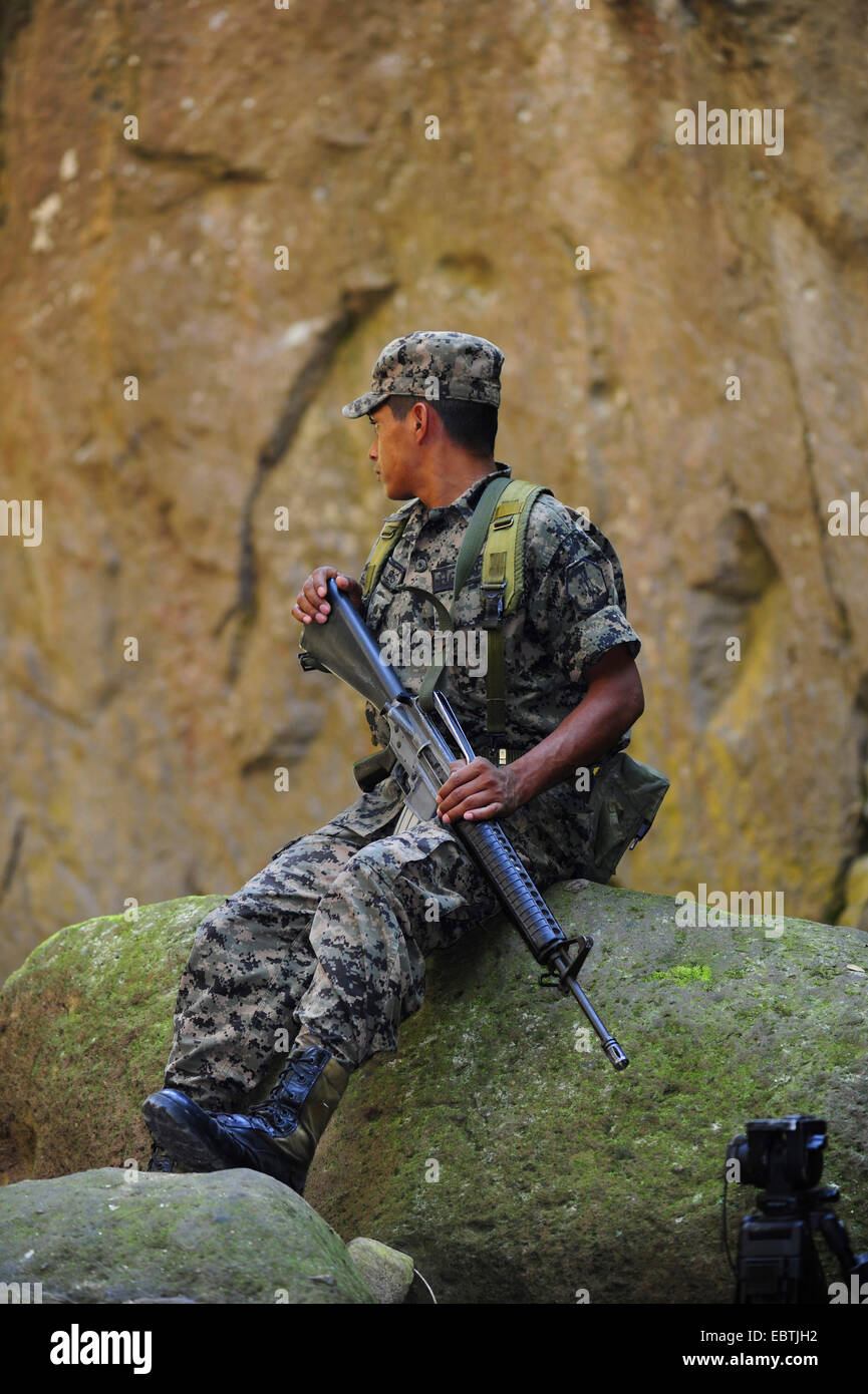 Les jeunes soldats armés assis sur une pierre , Honduras Copan, Banque D'Images