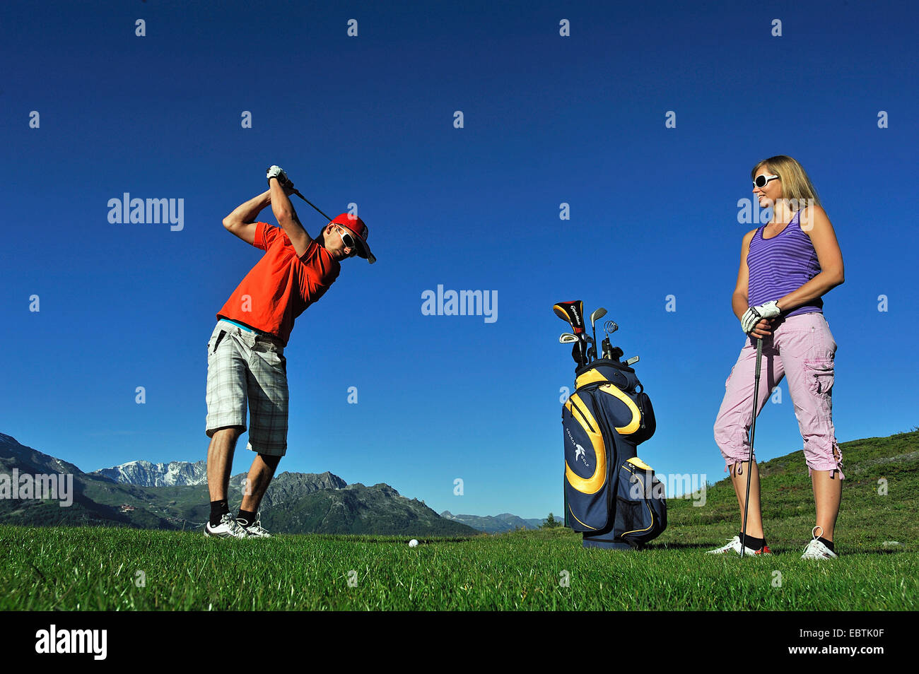 Jeune couple en jouant au golf, France, Savoie Banque D'Images