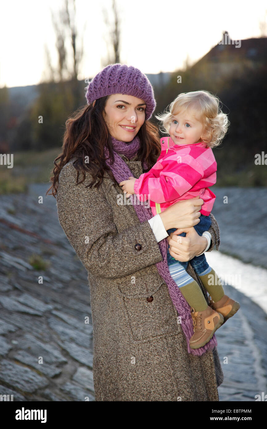 Young woman holding little girl sur bras Banque D'Images