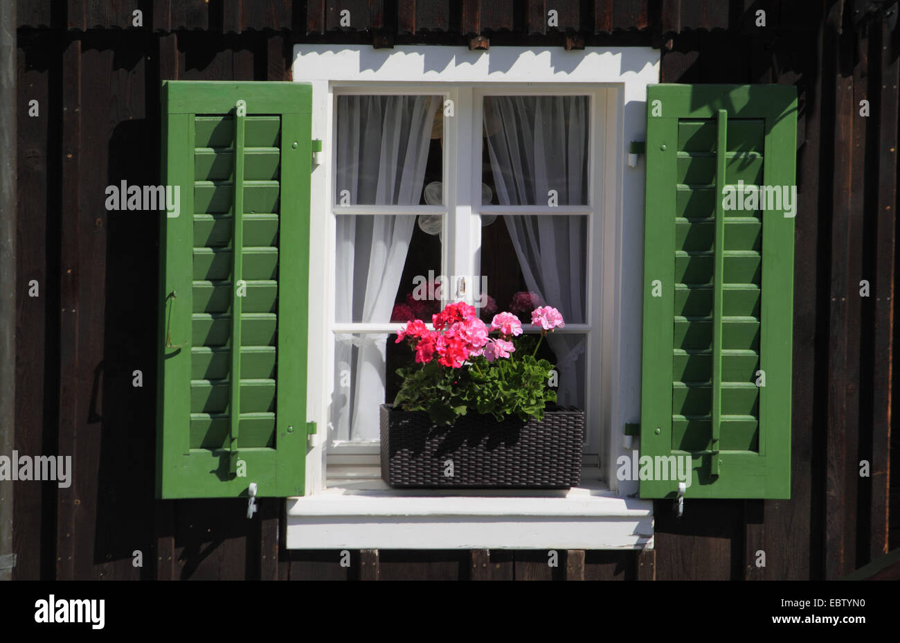 Fenêtre avec les volets ouverts et jardinière de géraniums, Suisse Banque D'Images