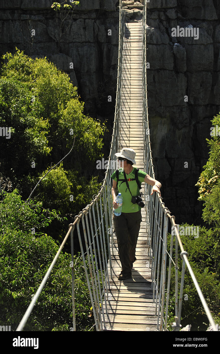 Femme debout sur le pont de planches, de Madagascar, le Parc National de l'Ankarana, Les Tsingy Banque D'Images