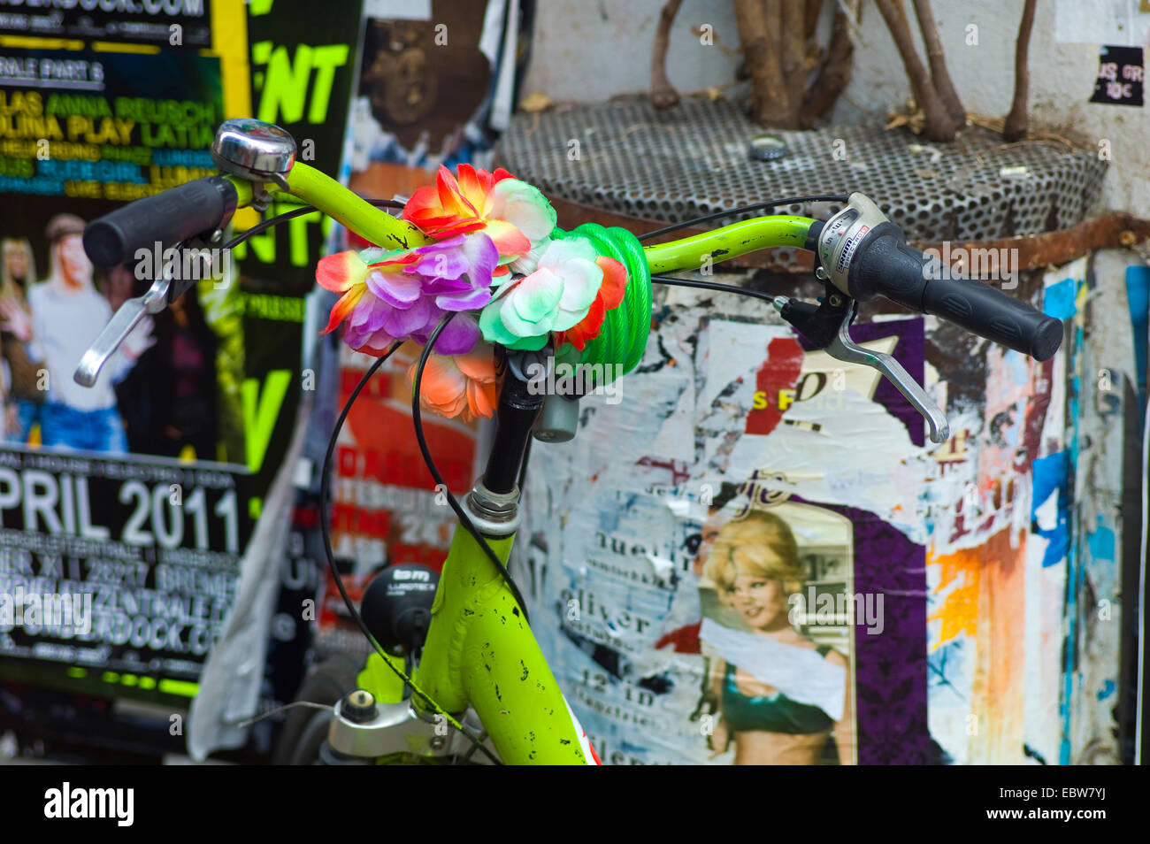 Vieux vélo en stationnement avec une décoration colorée sur le guidon à l'avant du mur de l'affiche, Allemagne Banque D'Images
