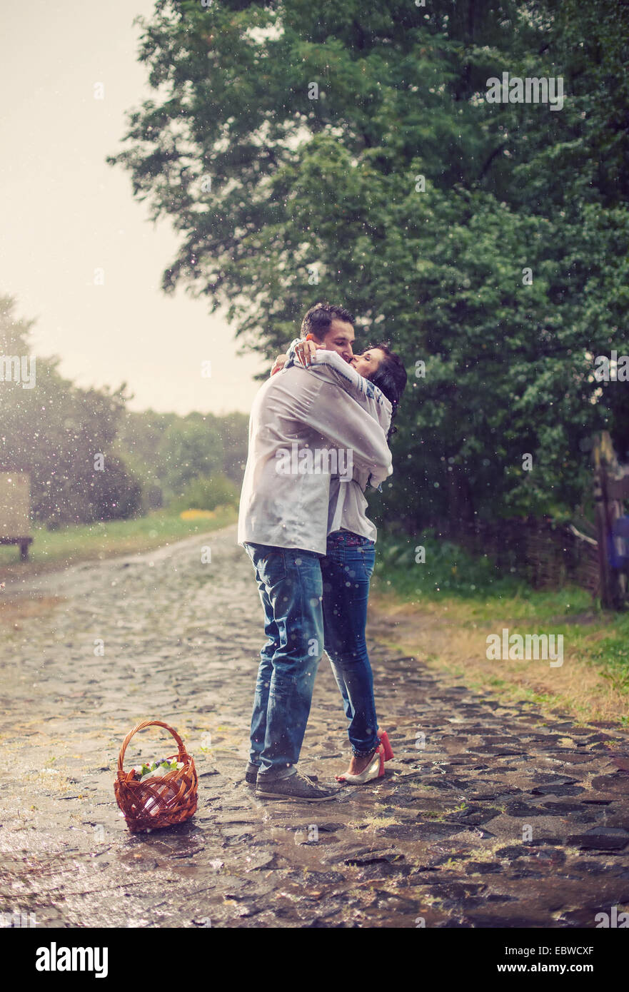 Jeune couple en ukrainien vêtements de style s'embrasser tout en se tenant sous la pluie Banque D'Images
