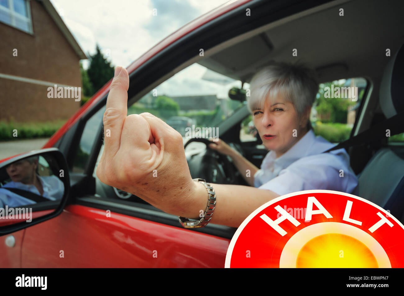Femme pilote automobile faisant un geste de la main rude au cours d'un contrôle de la circulation, Grevenbroich, Rhénanie du Nord-Westphalie, Allemagne, Banque D'Images
