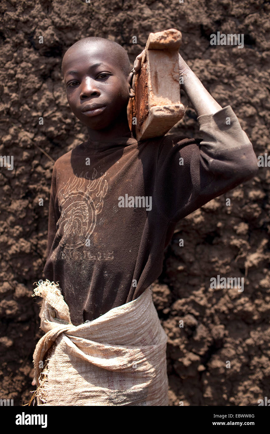 Garçon transportant un moule sur son épaule pour former des briques de boue avec qui sont ensuite brûlés dans un four traditionnel, Burundi, Kabezi, Kabezi Banque D'Images