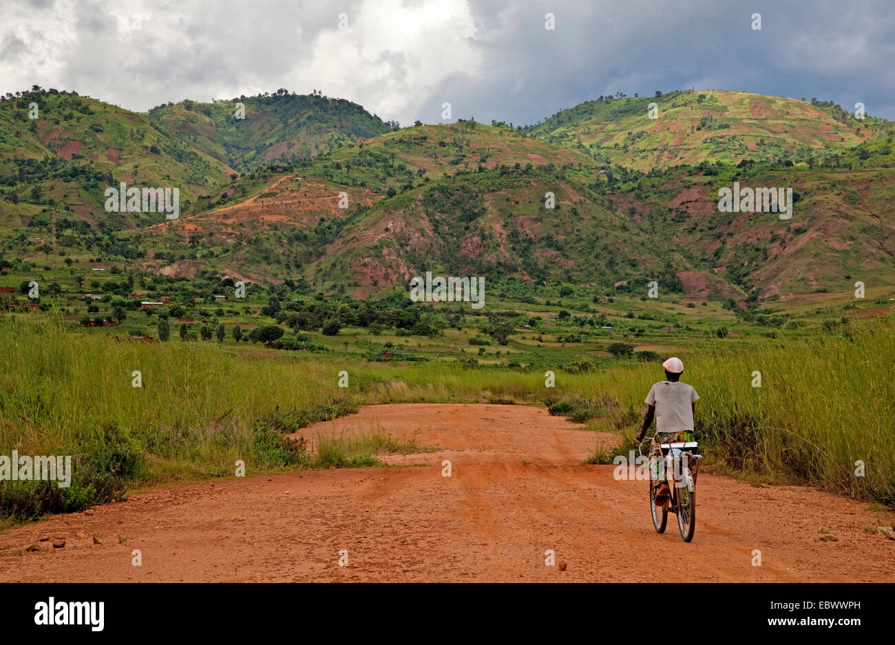 Un homme monté sur un vélo dans un paysage vallonné, au Burundi, Bujumbura Mairie, Bujumbura Banque D'Images