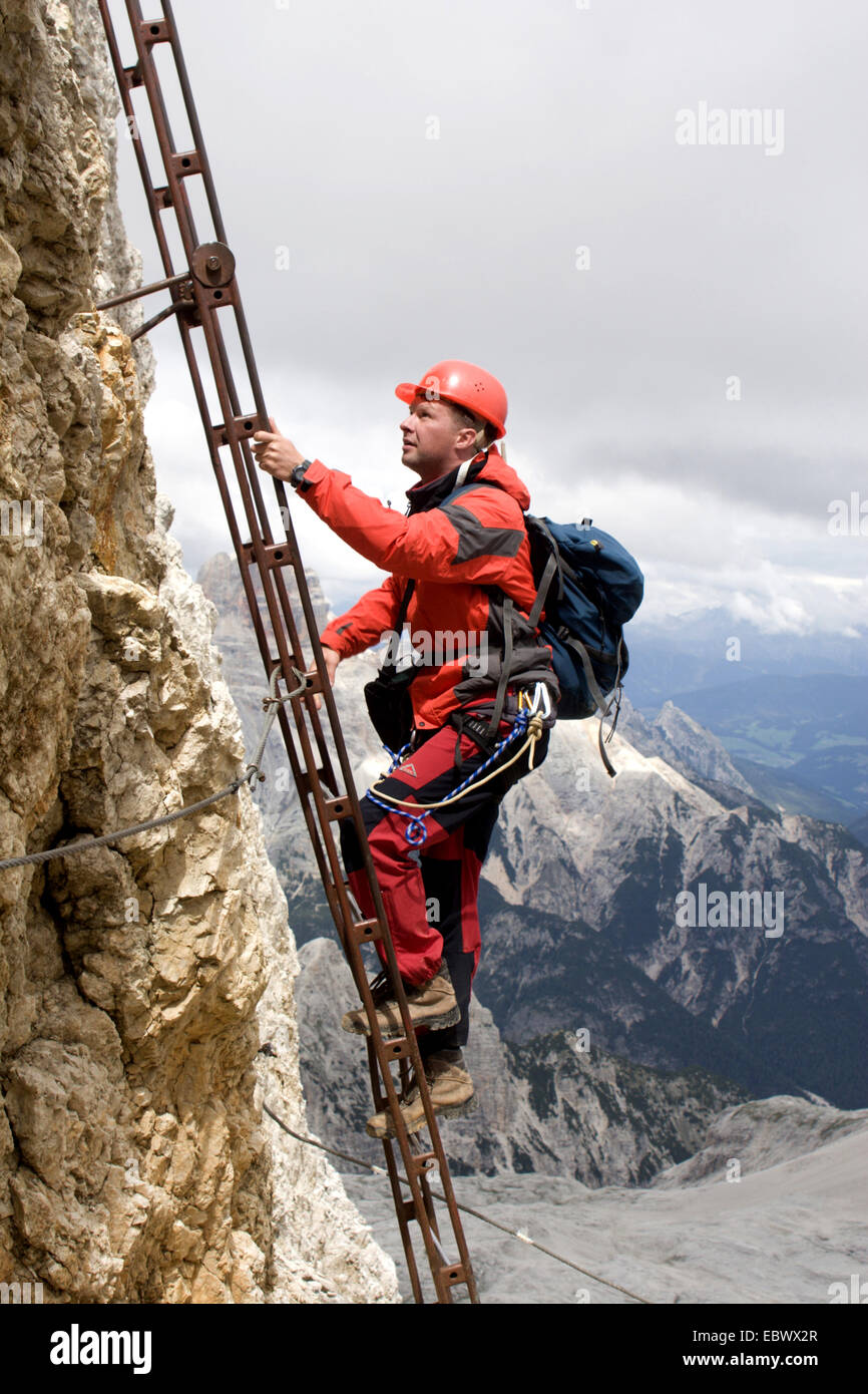 Sur l'échelle de l'alpiniste e à une face raide Banque D'Images