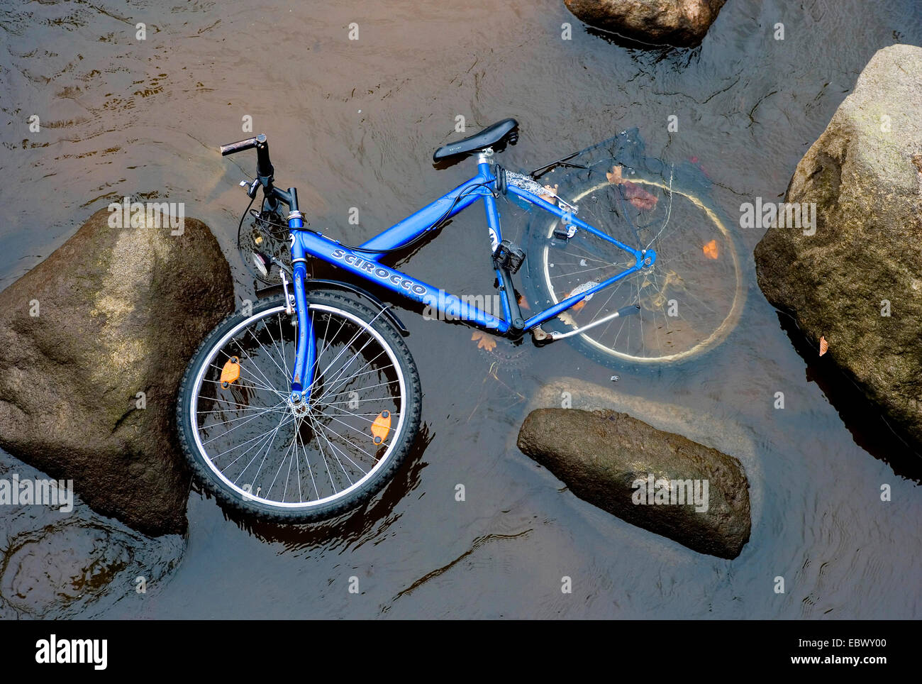 Nouveau bike bleu couché dans une eau peu profonde parmi les roches, Allemagne Banque D'Images