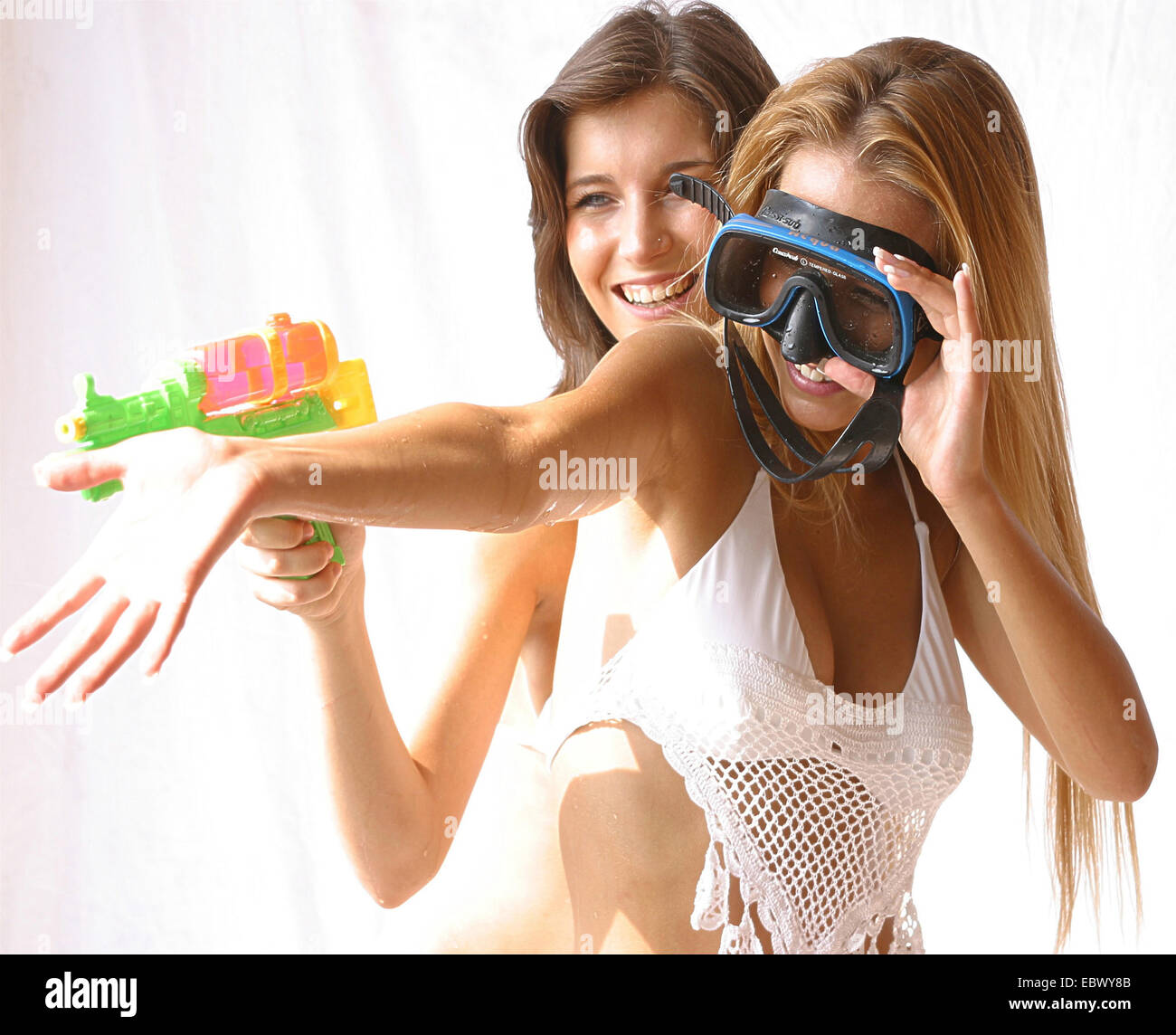 Deux belles jeunes femmes portant des bikinis de jouer avec des armes à feu et un masque de plongée awater Banque D'Images