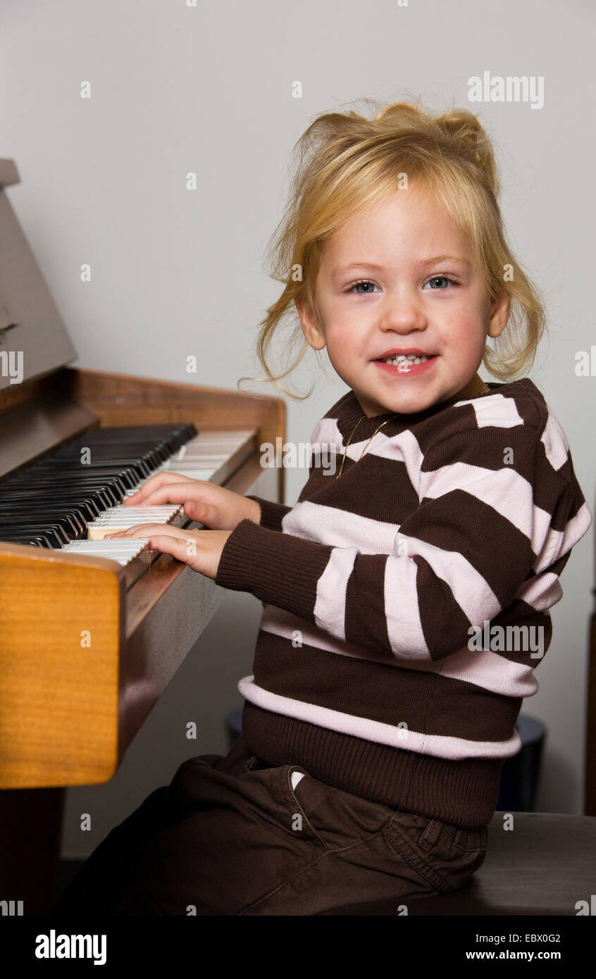 Enfant joue sur un piano Banque D'Images