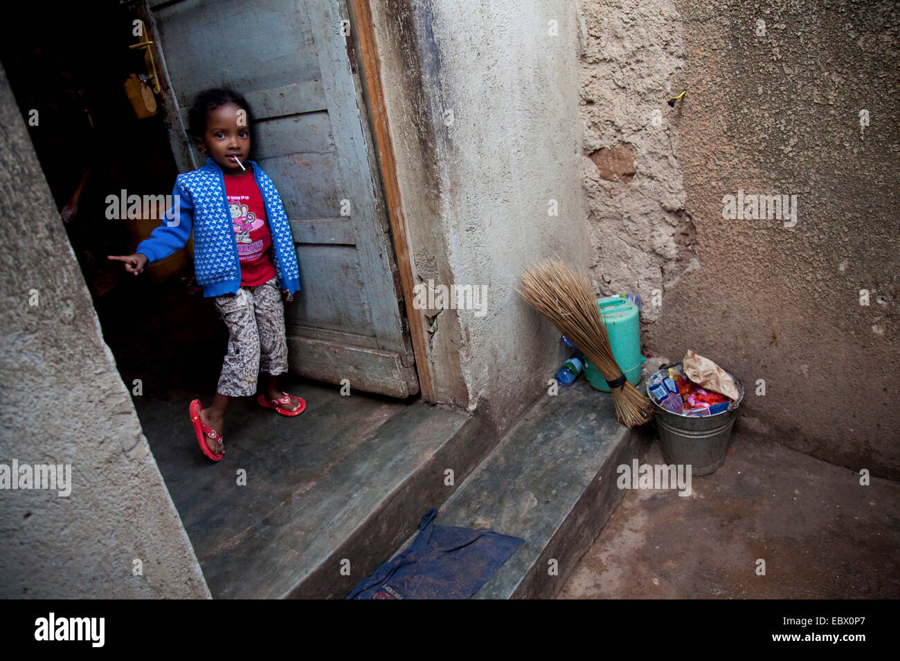 Petite fille dans un quartier pauvre de la capitale vagues dans la maison que vous approche, Rwanda, Kigali, Nyamirambo Banque D'Images
