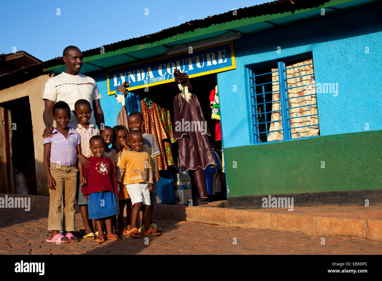 Queue devant son atelier avec un groupe d'enfants du voisinage, du Rwanda, de Nyamirambo, à Kigali Banque D'Images