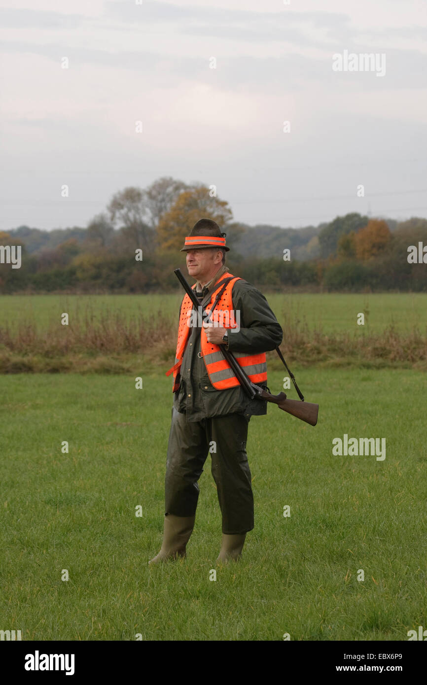 Hunter et permanent en attente dans une prairie au cours d'une battue en octobre, Allemagne Banque D'Images
