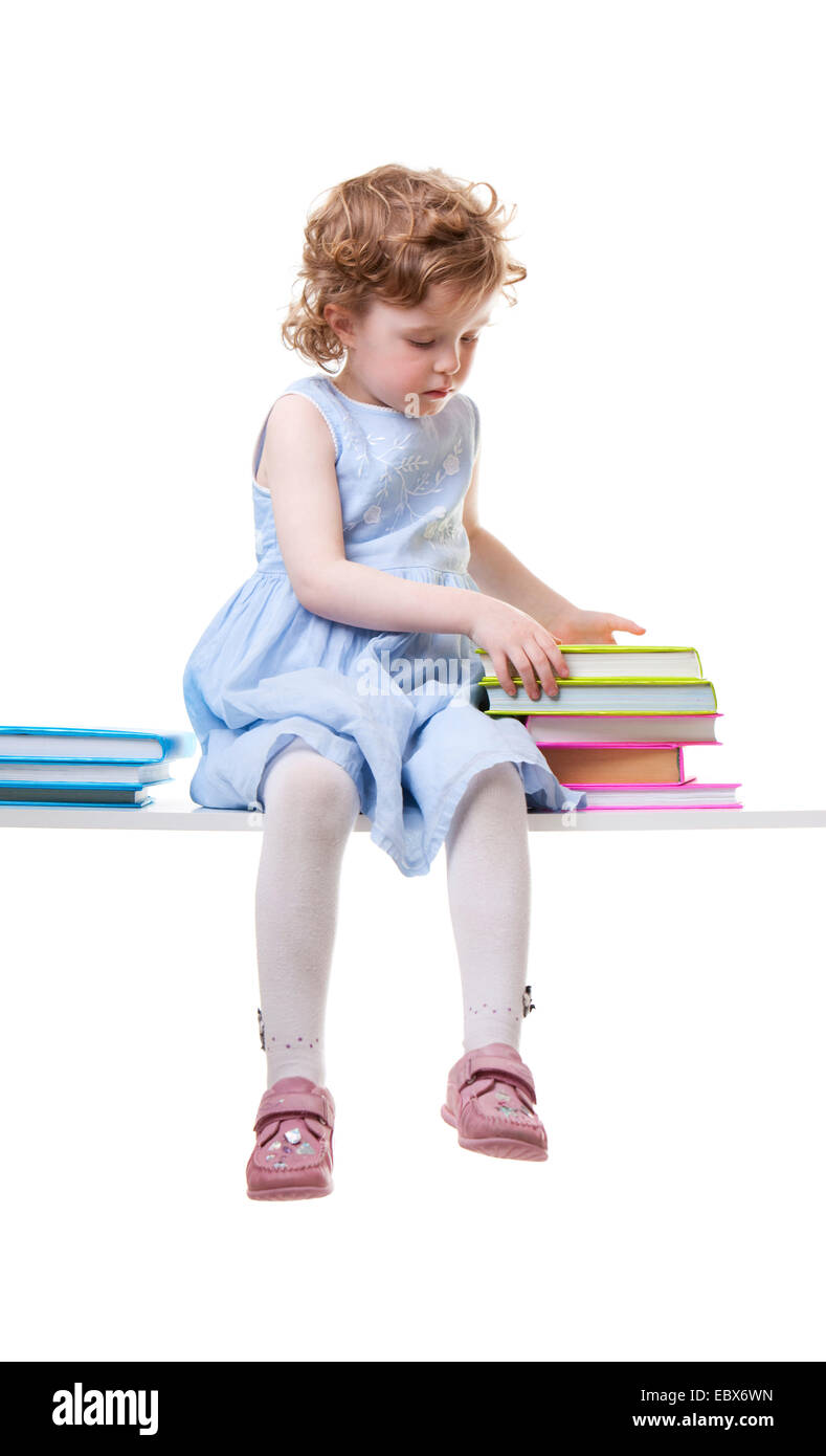 Little girl with books assis sur un banc Banque D'Images