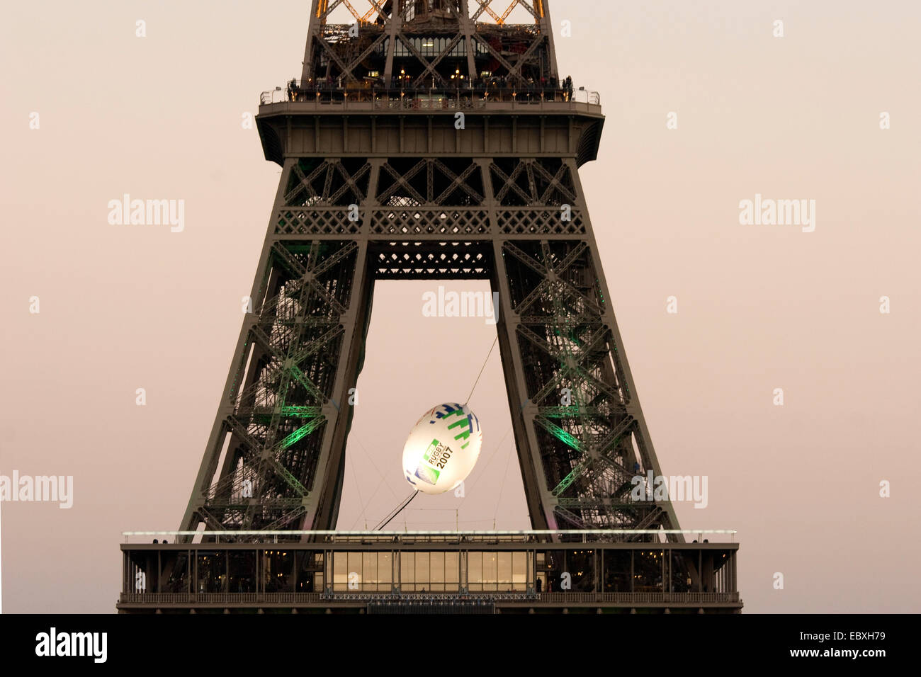 Voir à la Tour Eiffel avec un gros ballon de rugby entre les piliers, France, Paris Banque D'Images