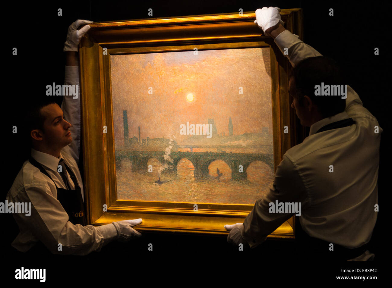 Londres, Royaume-Uni. 5 Décembre, 2014. Maison de renommée mondiale aution Sotheby's est d'offrir une collection de maîtres britanniques et continentaux d'être vendu aux enchères le 10 décembre 2014. Photo : Sotheby's gallery hang techniciens artiste Belge Emile Noël peinture impressionniste de Waterloo Bridge avec les Chambres du Parlement et Big Ben en arrière-plan, ce qui est prévu pour aller chercher entre 200 à 300 € 000 à l'enchère. Crédit : Paul Davey/Alamy Live News Banque D'Images