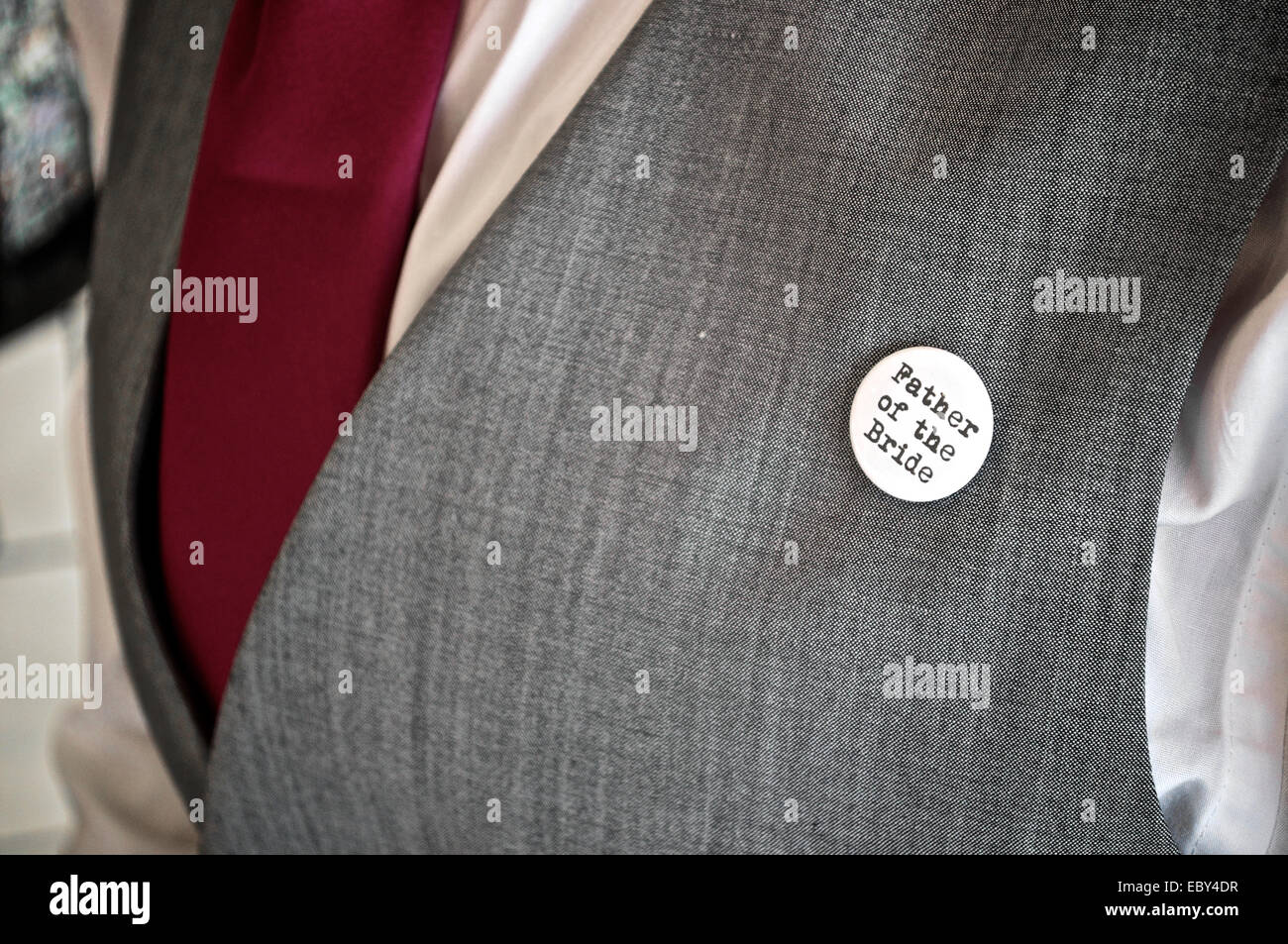Le père de la mariée d'un insigne sur une boutonnière du groomsman. Banque D'Images